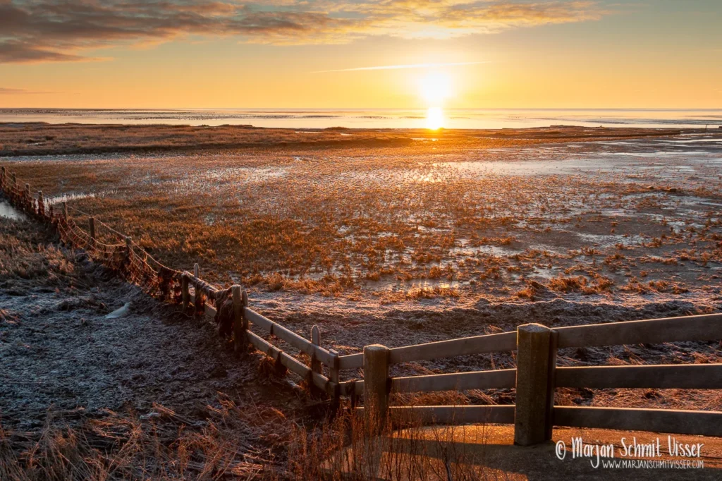 Aan de Nederlandse kust 26 Aan de Nederlandse kust Zonsopkomst boven het Wad bij Striep op Terschelling, Nederland, met bevroren kwelder en warme ochtendkleuren.